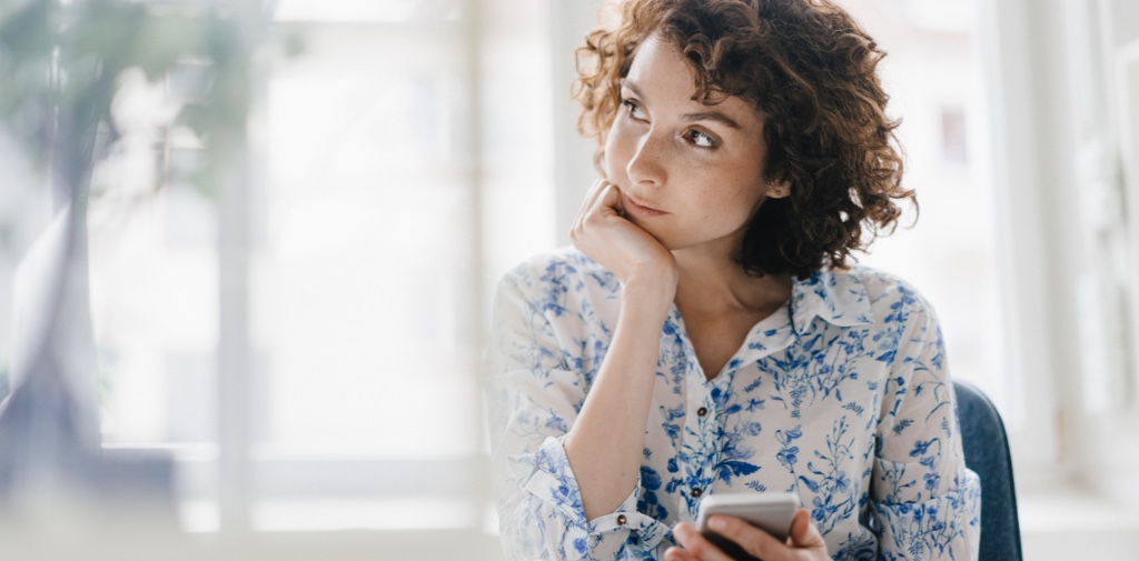 A woman looks off camera in home office.